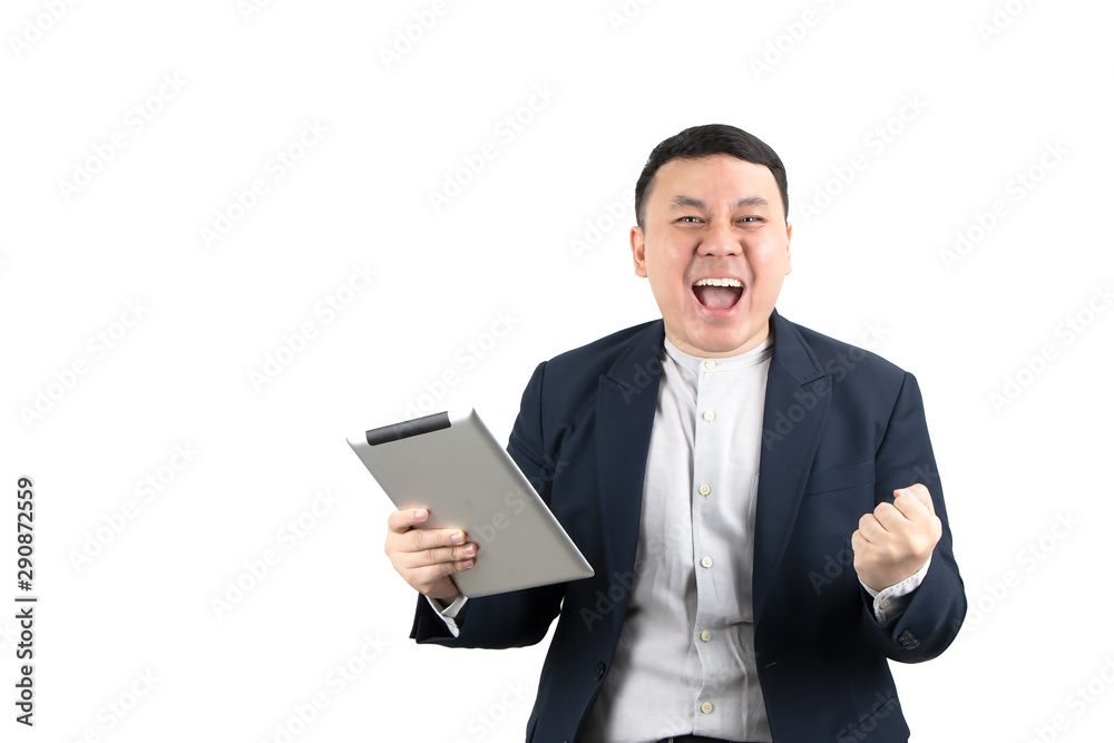 Excited young Asian businessman holding tablet with fist hand, celebrating success isolated on white background with copy space. Technology, online marketing, e-commerce, startup business concept.