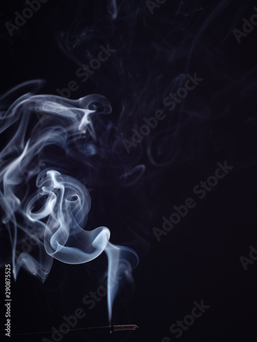 Abstract cloud of white smoke from burning incense, isolated on black background, close up view. Structure of white smoke, brush effect. Fragrance for meditation and relaxation, abstract background