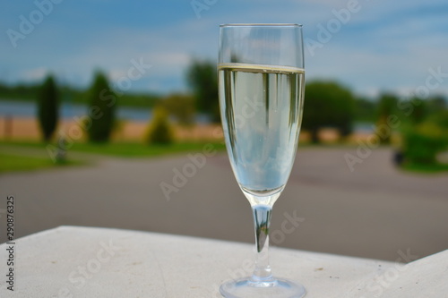 Tall champagne glass on concrete railing.