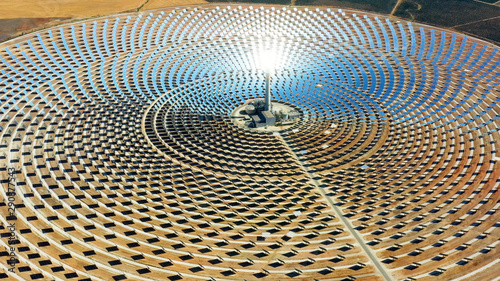 Beautiful large circular power plant of solar panels in Spain. There is the reflection of the sun in the the panels which produce renewable energy, solar energy - close-up view with a drone - environm