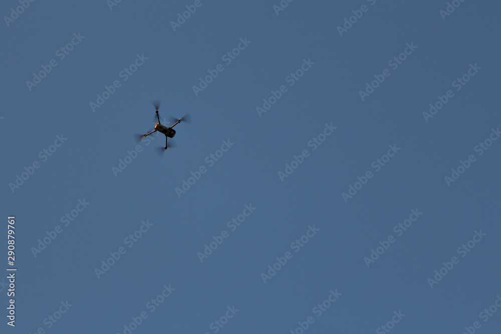 Copy space. Flying a quadcopter in the blue sky. Car on blue background