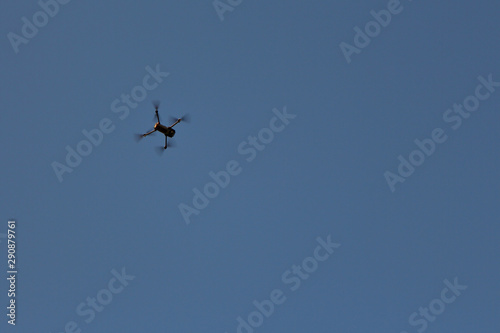 Copy space. Flying a quadcopter in the blue sky. Car on blue background