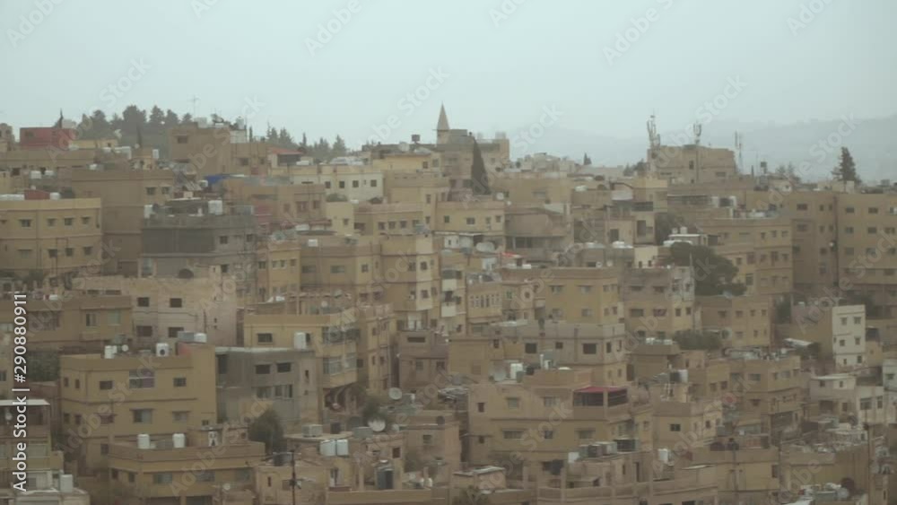 man sitting on a rooftop with buildings on front man sitting on a rooftop with buildings on front