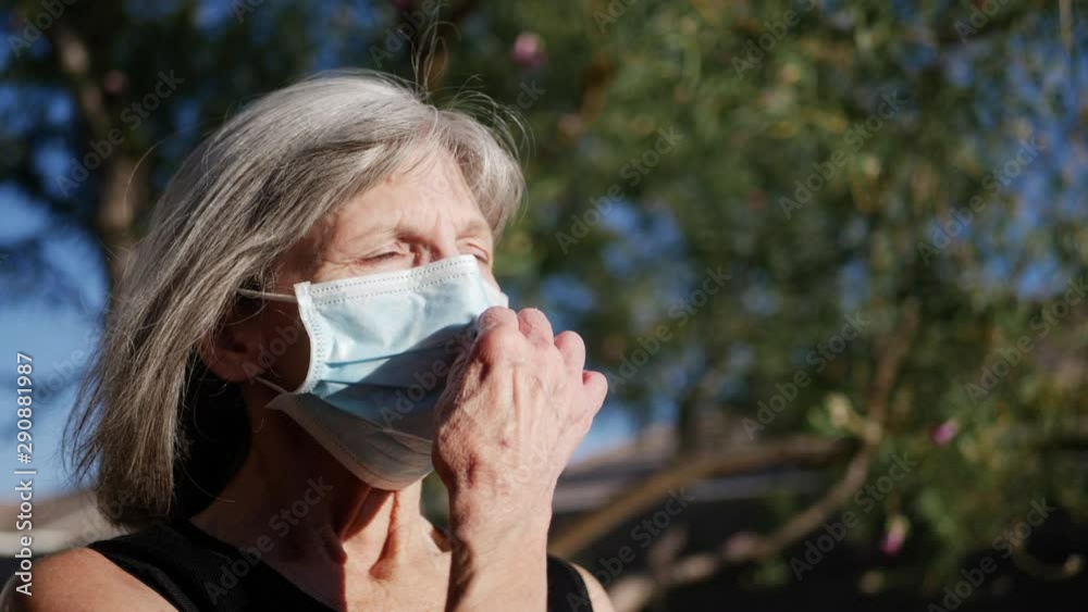 An aging woman patient with cancer breathing fresh air and smiling with hope after being cured of her disease. An aging woman patient with cancer breathing fresh air and smiling with hope after being cured of her disease.