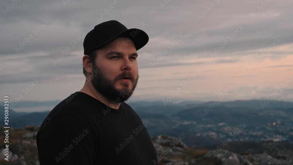 Man lifting his head and wisely looking at the view he is facing with mountains in the background - 4K Slowmotion Man lifting his head and wisely looking at the view he is facing with mountains in the background - 4K Slowmotion