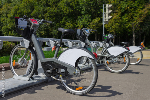 Bicycles for rent are on a bicycle parking lot on a city street