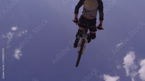 Extreme sports BMX flip over the camera and blue sky