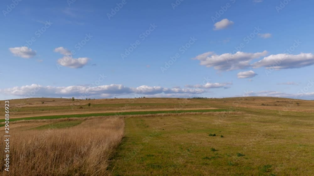 Empty agricultural field at autumn panning shot, blue sky with white clouds in Transylvania, Romania. Empty agricultural field at autumn panning shot, blue sky with white clouds in Transylvania, Romania.