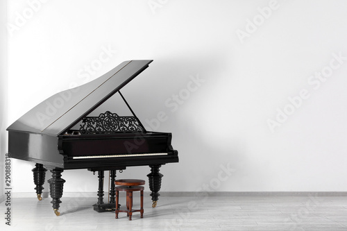 Black grand piano near white wall in empty room photo