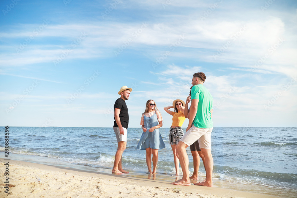 Happy friends on sea beach at resort