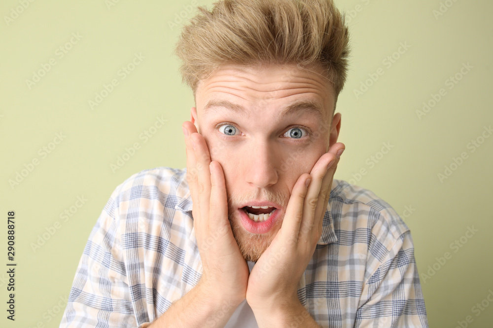 Shocked young man on color background Shocked young man on color background