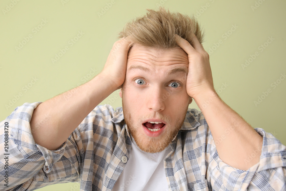 Shocked young man on color background Shocked young man on color background