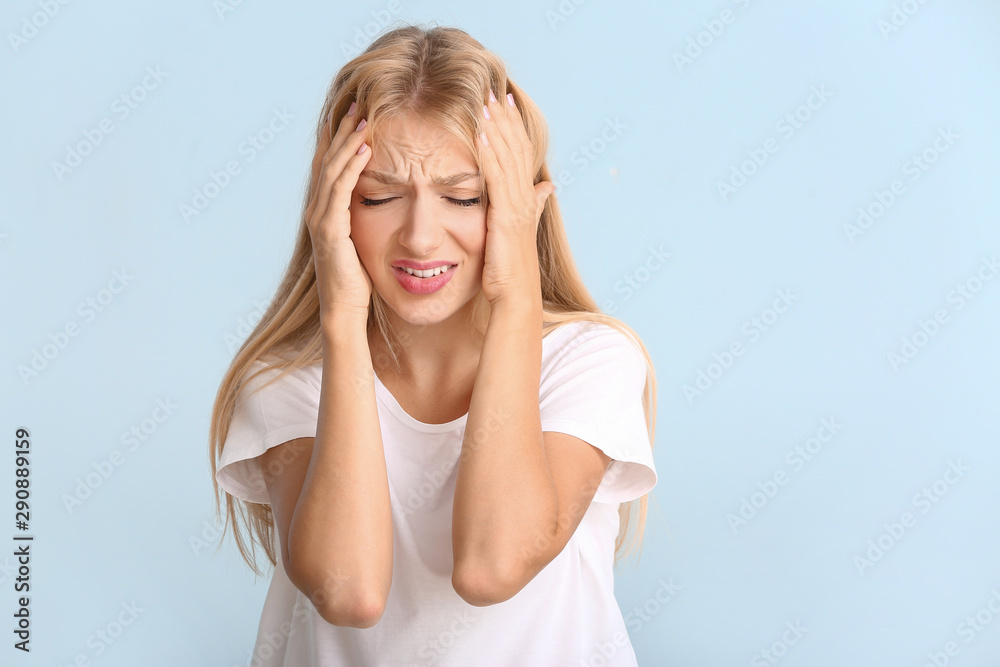 Fototapeta premium Stressed young woman on color background