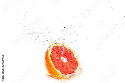 Fototapeta Naklejka Na Ścianę i Meble -  fresh big ripe grapefruit falling in water - splash