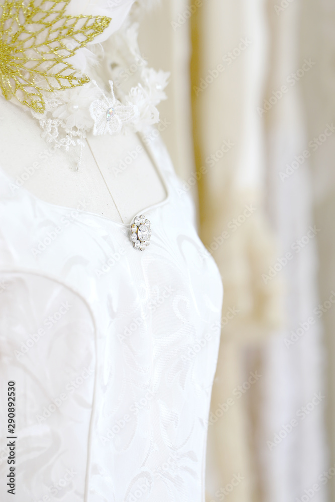 Wedding white gown for bride hanged in costume showroom for marriage or wedding reception. White delicated lace on long dress for promp or party Wedding white gown for bride hanged in costume showroom for marriage or wedding reception. White delicated lace on long dress for promp or party