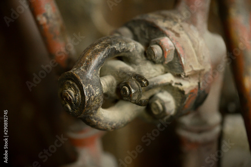 An aged rusty circle shaped tap in old abandoned factory. Close up of a metal faucet that has not been used for ages.