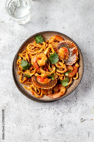 Seafood Spaghetti with seashells, prawns, squids on gray background. Italian mediterranean food concept
