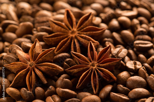 Three anise stars spice on the coffee beans background, close up.