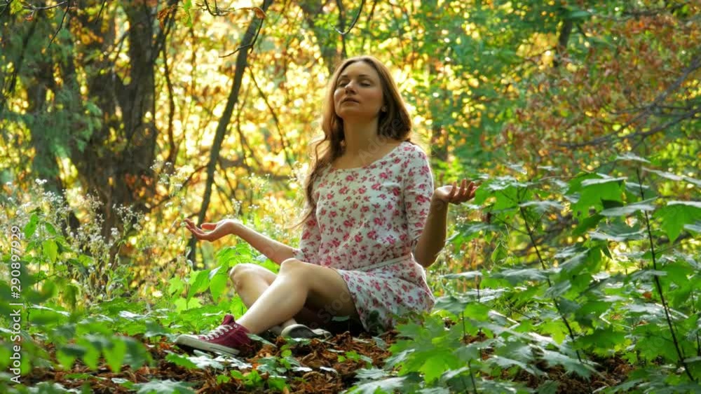 Cheerful young woman meditate at summer park Cheerful young woman meditate at summer park