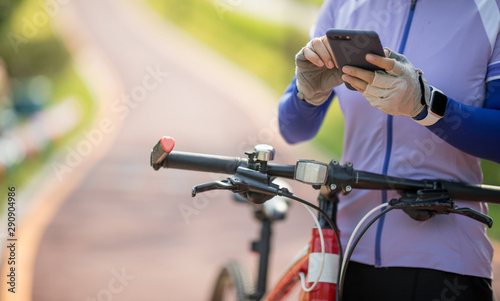 Using smartphone while riding bike on sunny day