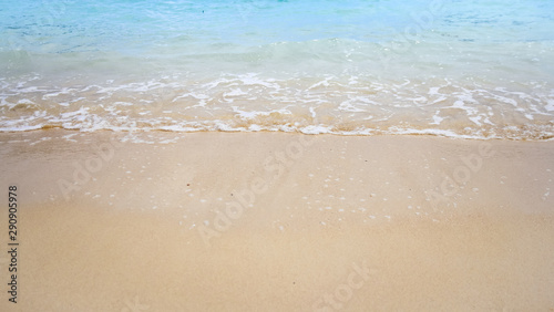 Summer background of blue sea wave and brown beach sand 