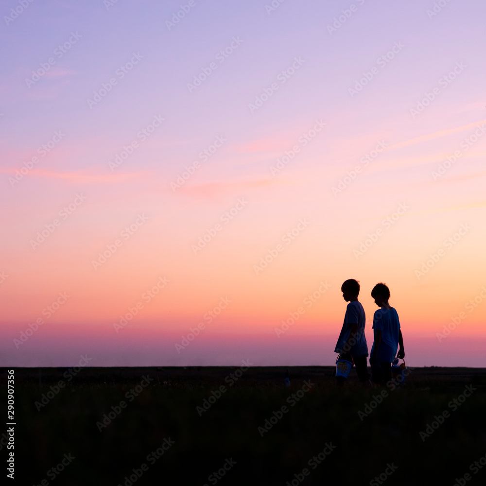 silhouette of two boys against colorful sunset