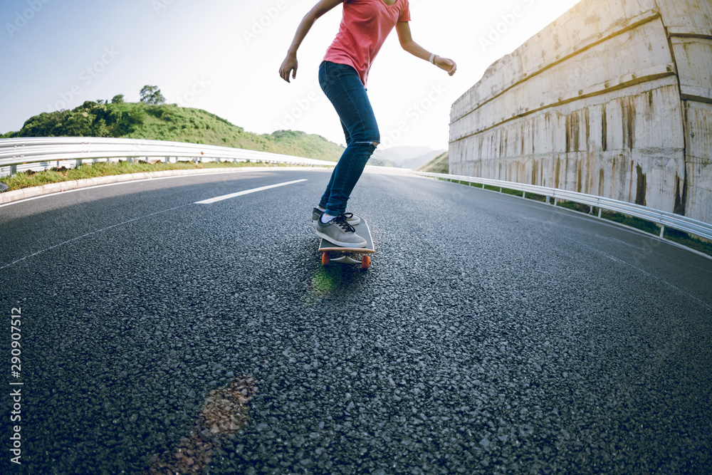 Obraz premium Skateboarder skateboarding on highway road