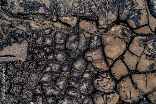 Black cracked surface. Old bitumen texture. Black background © Dmitrii