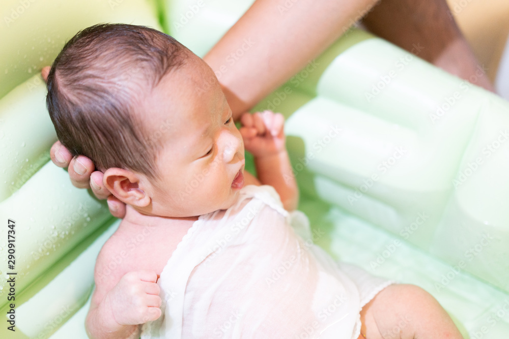 Father bathing baby in baby bath Father bathing baby in baby bath