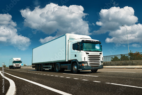 White truck is on highway - business, commercial, cargo transportation concept, clear and blank space on the side view