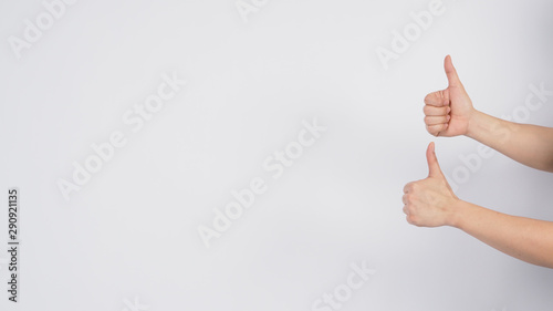 Male's hand doing thumbs up sign on white background.