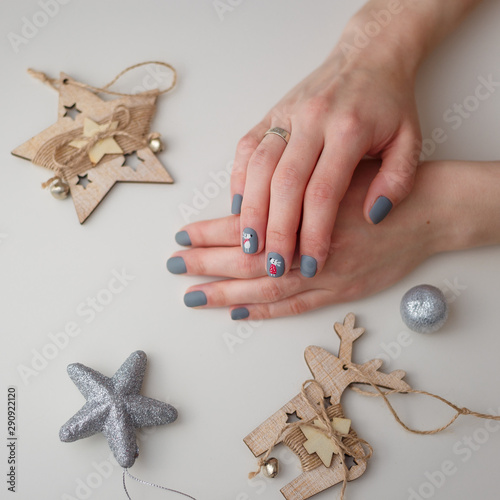 female hands with christmas deer manicure on the finger nails photo