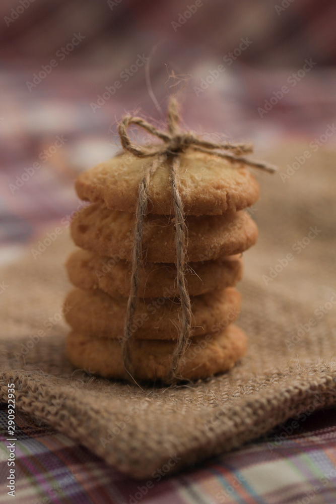 Fototapeta premium Round sweet cookies. Delicious dessert with high sugar and carbohydrate suitable for eating with milk and tea or coffee on color and white background with colorful placemat