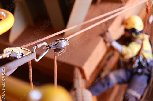 2 descenders 2 low stretch rope access equipment rigging as a tie line, while defocused rope access technician working at height hanging on rope the background construction site, Sydney, Australia     photo