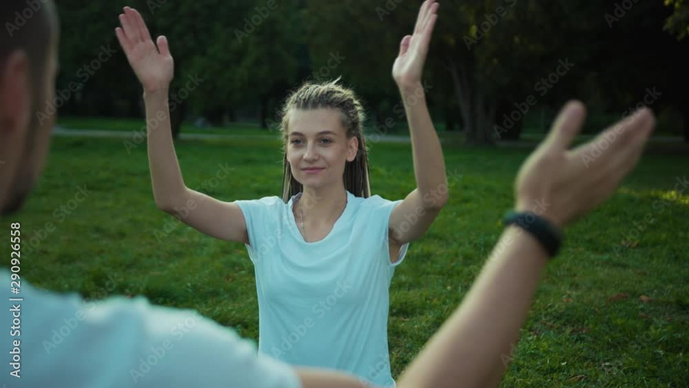 Couple of young athlets practising asana in yoga poses. Man and woman training yoga exercising on summer morning in wonderful valley. Couple of young athlets practising asana in yoga poses. Man and woman training yoga exercising on summer morning in wonderful valley.