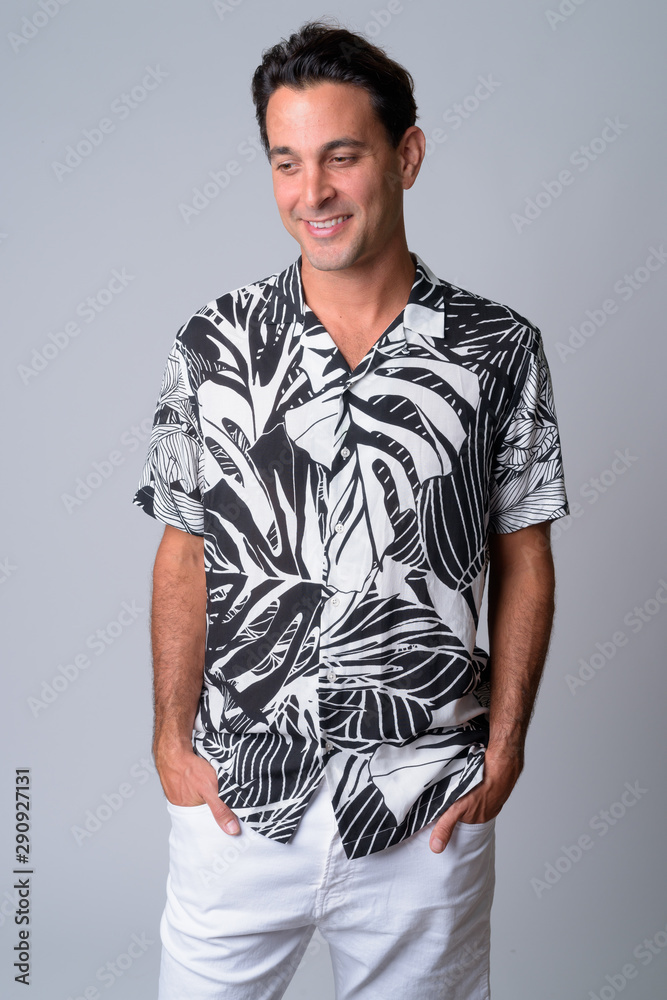 © Ranta Images - Portrait of happy handsome Hispanic tourist man thinking and looking down