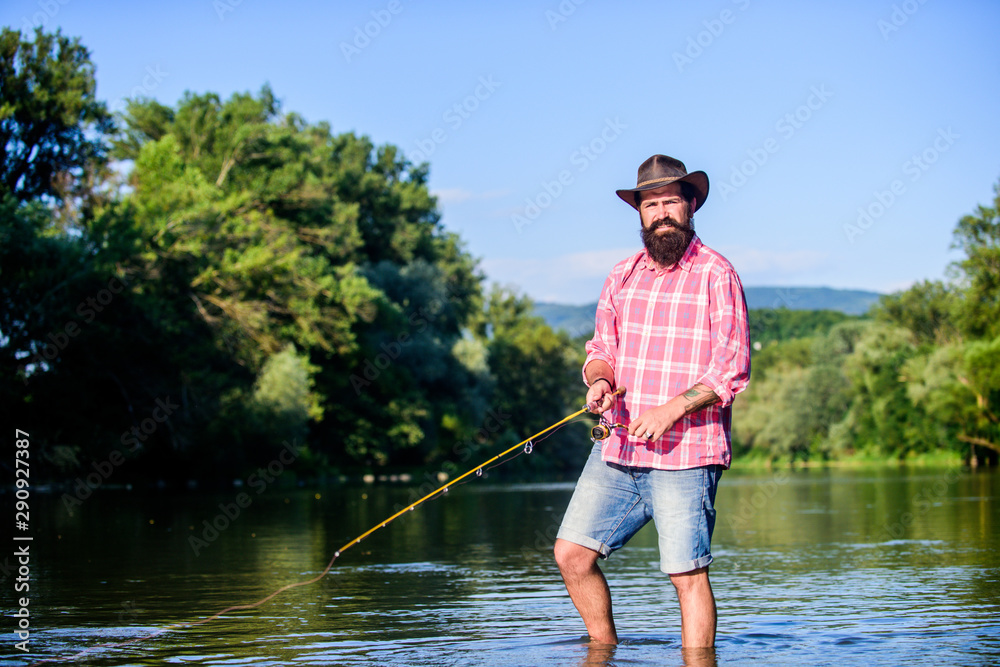 fly fish hobby. Summer fishery activity. hipster fishing with spoon-bait. big game fishing. relax on nature. successful fisherman in lake water. mature bearded man with fish on rod. hipster fun