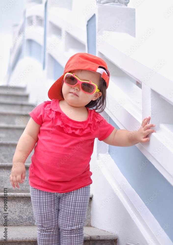 A fat baby girl posing for the camera while working down stairs