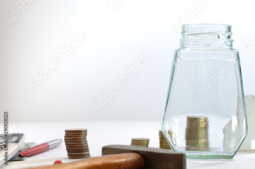 Coin stacked, glass jars, pens and calculators placed on a white background, images for financial business concepts with copy space