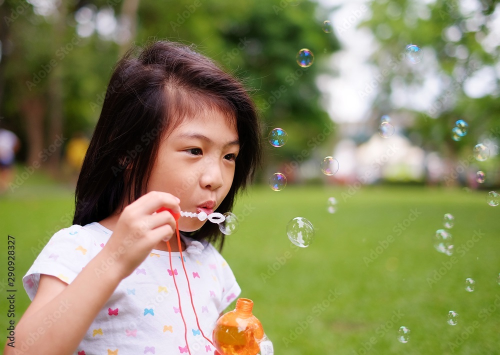 A cute Asian girl playing with bubbles, blowing them into the air. A cute Asian girl playing with bubbles, blowing them into the air.