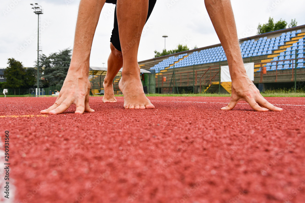 Barefoot athlete in starting position Barefoot athlete in starting position
