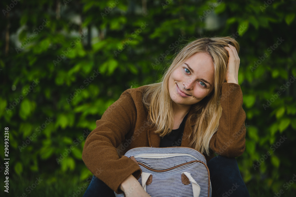 Hipster young woman in park with a backpack Hipster young woman in park with a backpack