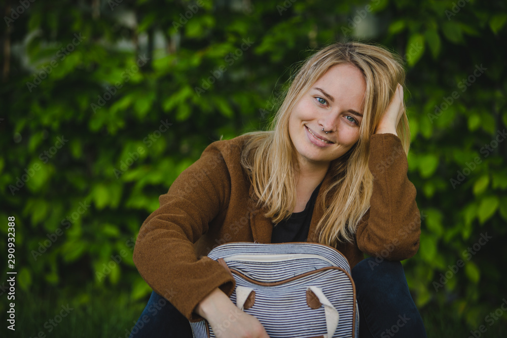Hipster young woman in park with a backpack Hipster young woman in park with a backpack