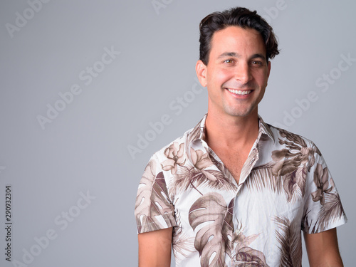 Face of happy handsome Hispanic tourist man smiling