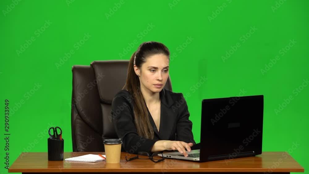 Business woman sitting at desk in leather chair and drink coffee. Green screen. Studio Business woman sitting at desk in leather chair and drink coffee. Green screen. Studio