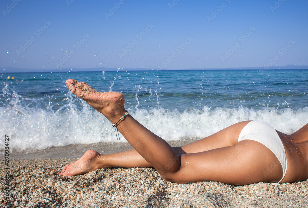 Close up outdoor shot of beautiful woman legs on the sea shore - obrazy, fototapety, plakaty 