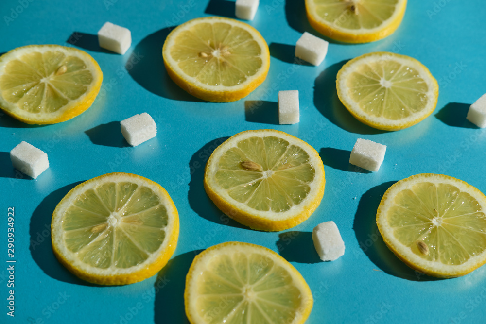 Lemon slices and sugar cubes on a blue background