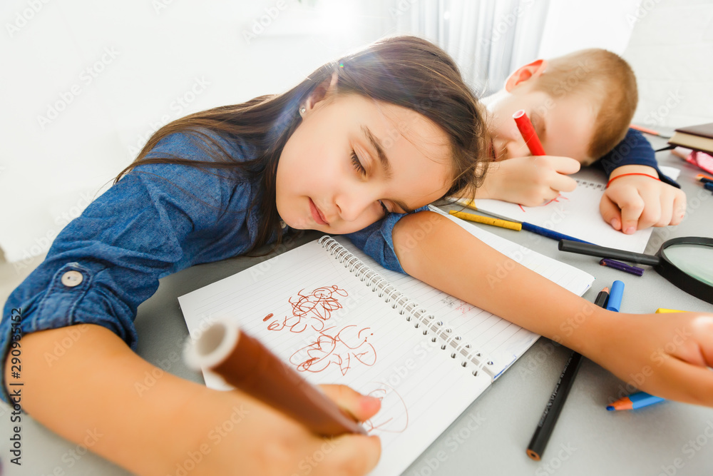 Little girl and little boy fell asleep while they were doing their homework Little girl and little boy fell asleep while they were doing their homework