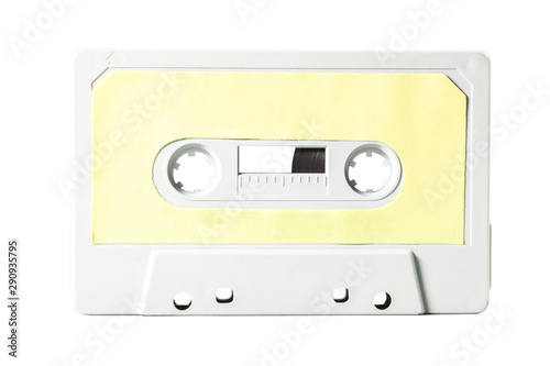 Close-up front shot: an old vintage cassette tape (obsolete music technology). Pale yellow label over a white plastic body.