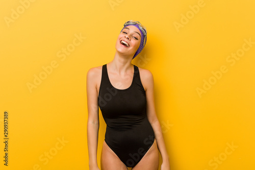 Young swimmer caucasian woman relaxed and happy laughing, neck stretched showing teeth.